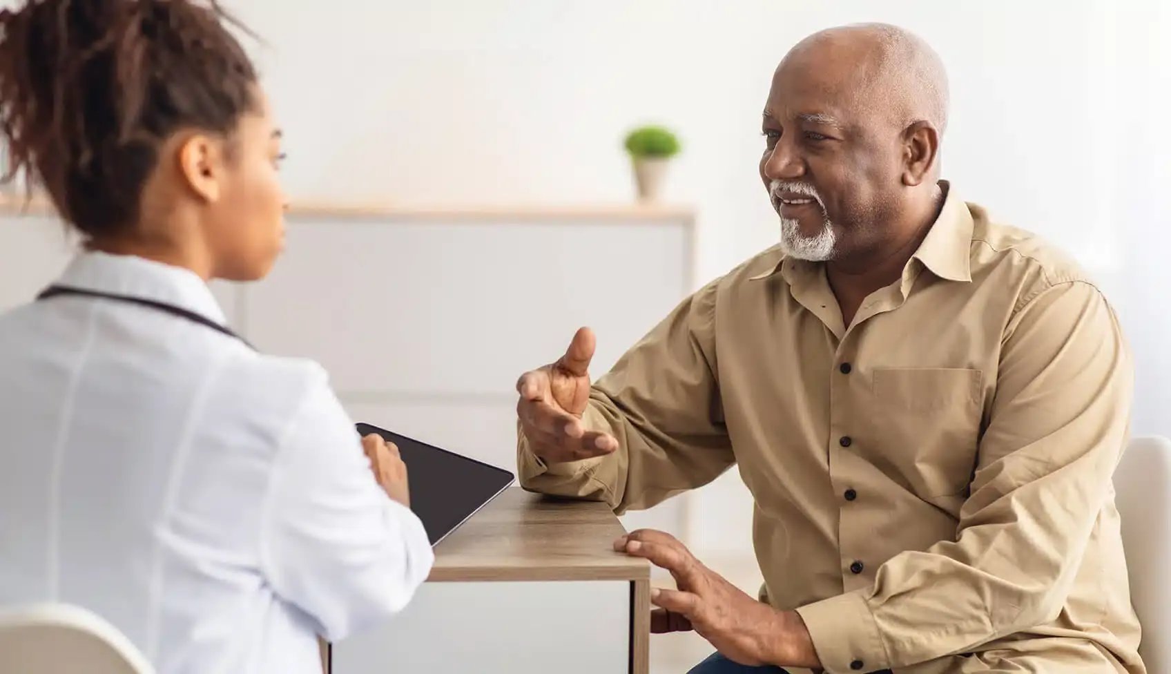An-elderly-patient-is-talking-to-a-young-practitioner